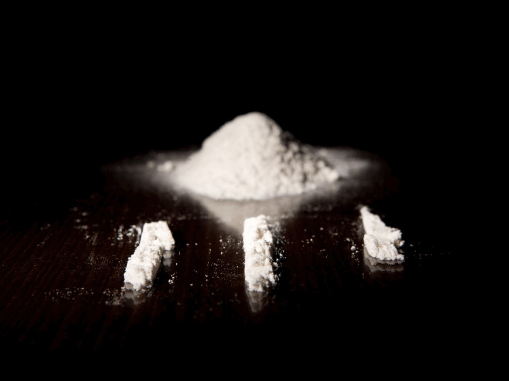Cocaine powder arranged in lines on a dark table representing cocaine abuse and addiction risks