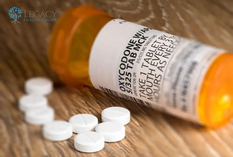Prescription bottle with Percocet pills spilled on table showing opioid medication and addiction risk
