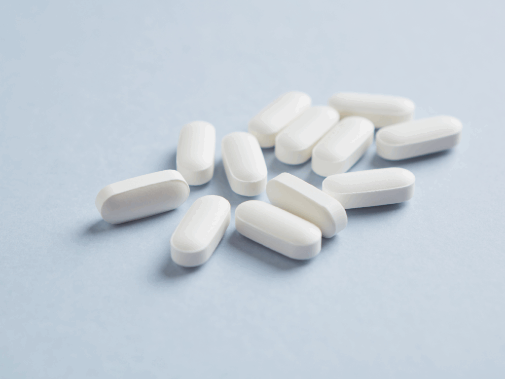 White Percocet pills on blue background representing opioid pain medication and addiction risk