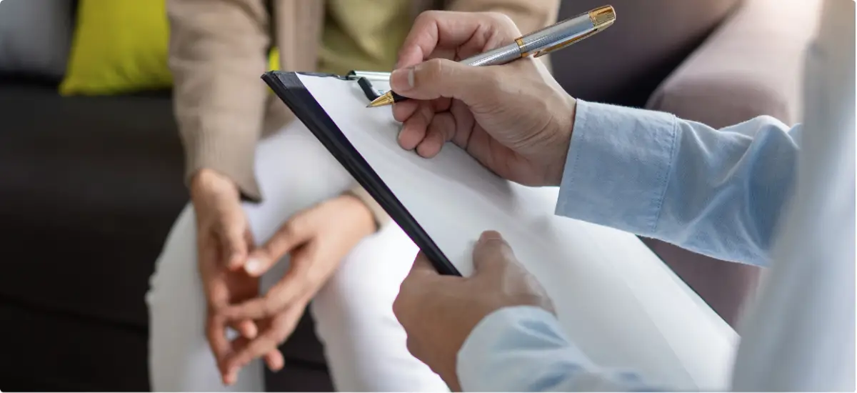 Confidential notes being taken during a private addiction treatment consultation.